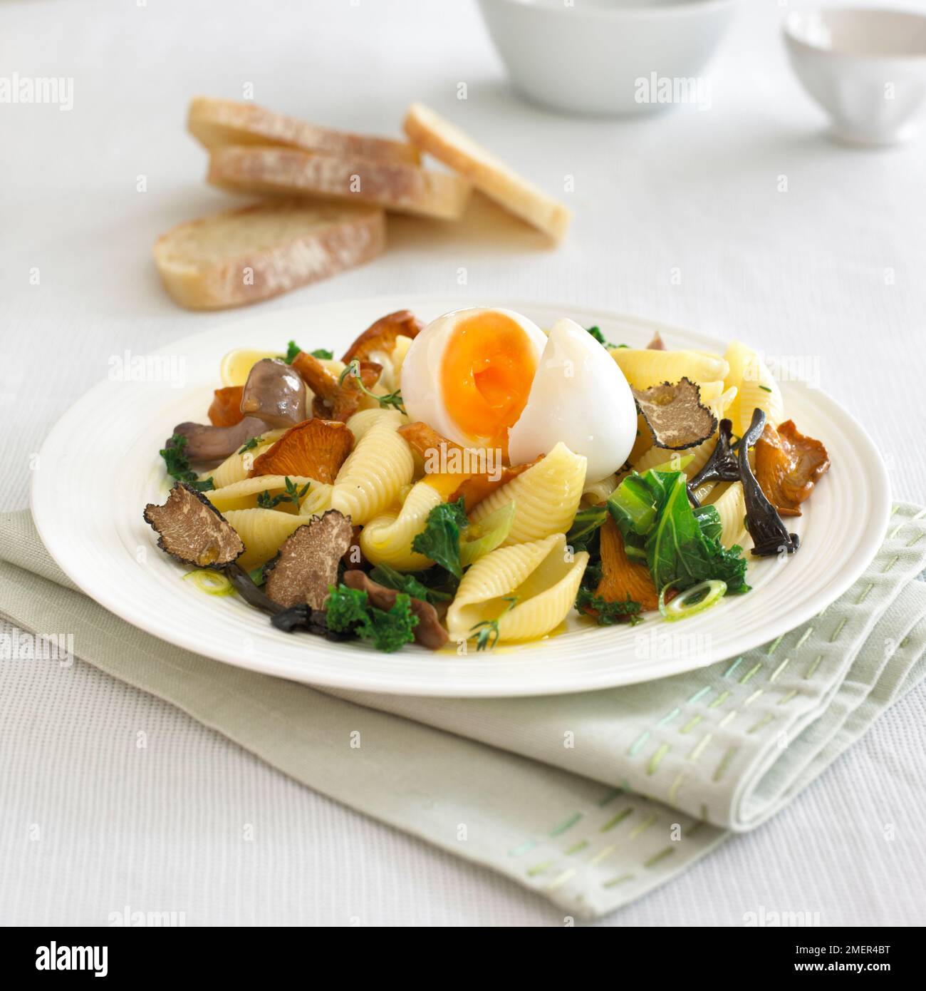 Pasta calda, kale, funghi misti e insalata di uova d'anatra con olio al tartufo Foto Stock
