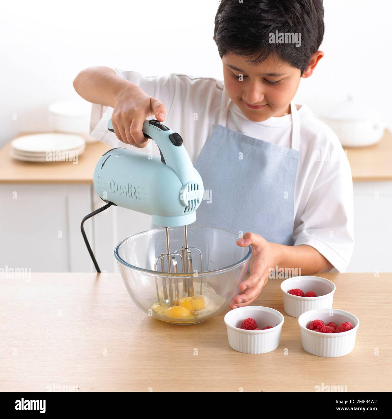 Ragazzo frustando ciotola di uova con frusta elettrica, 9 anni Foto stock -  Alamy
