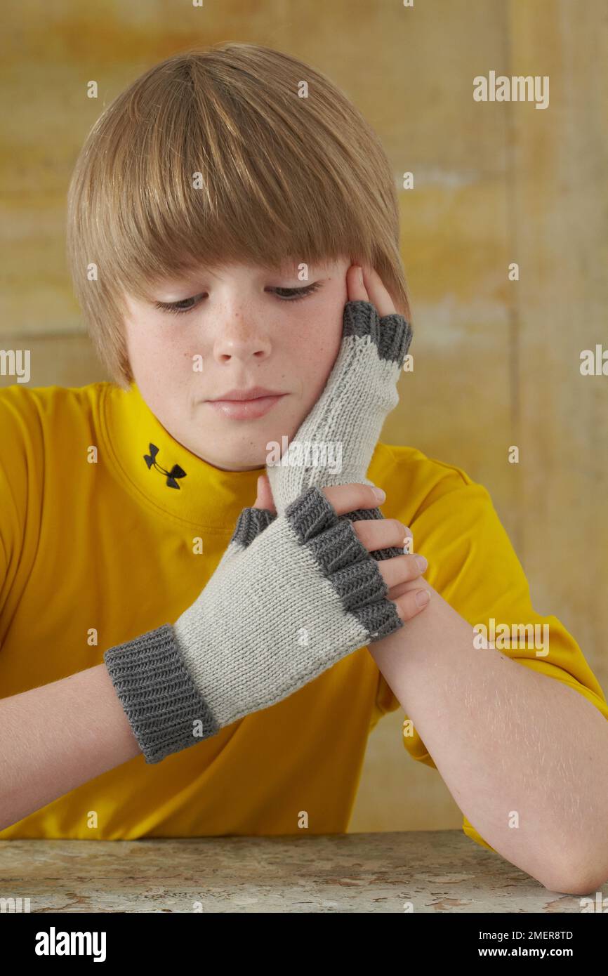Ragazzo che indossa guanti senza dita Foto Stock