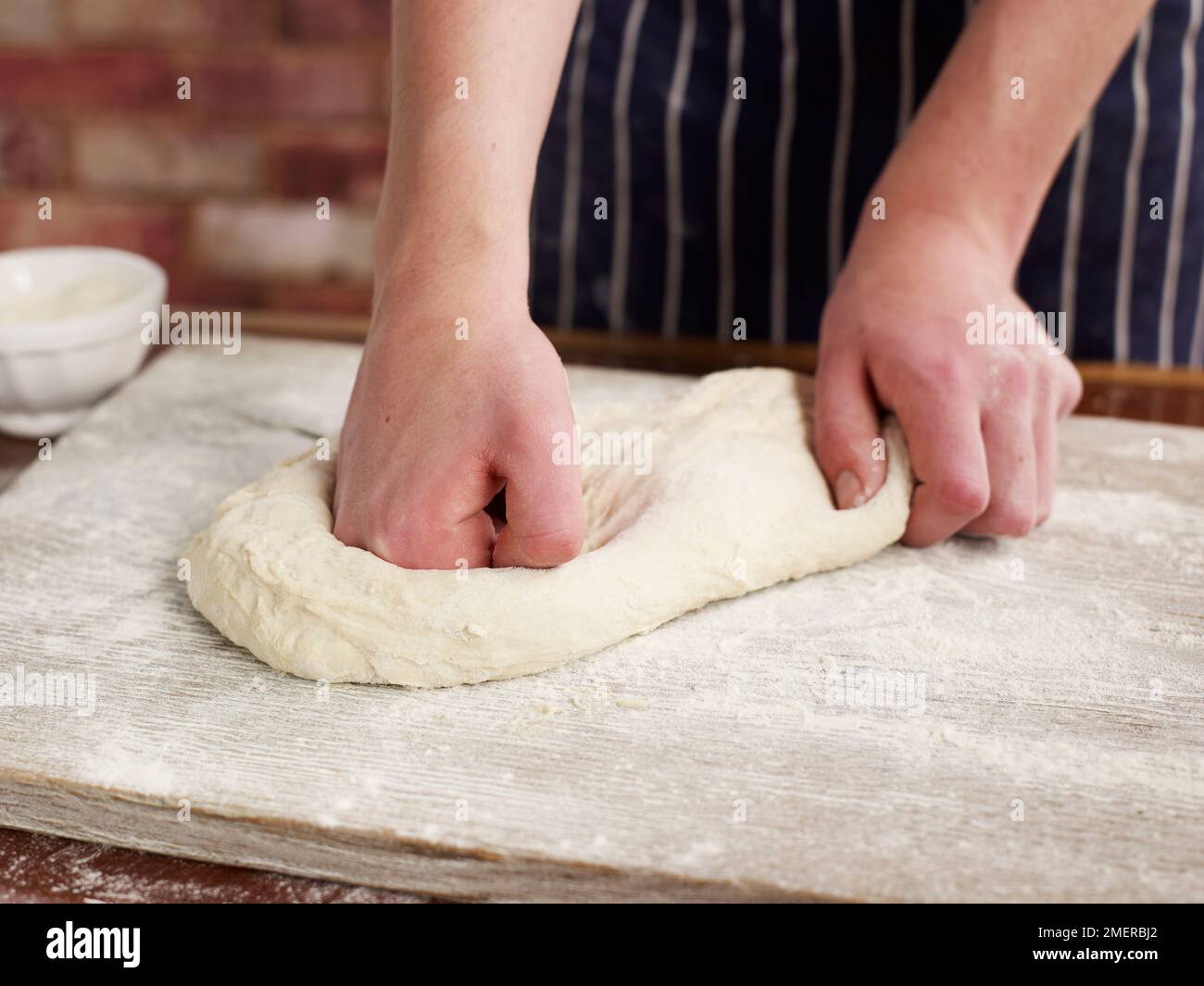 Preparare il pane, impastare l'impasto su una superficie infarinata Foto Stock