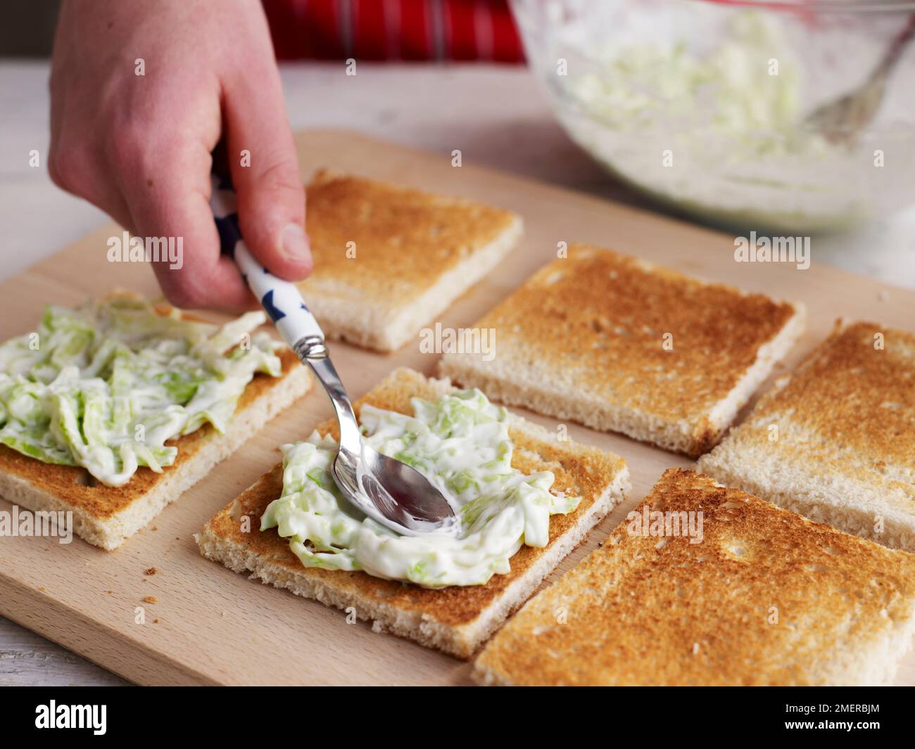 Club sandwich, spalmando maionese e lattuga mescolate su fette di pane bianco tostate Foto Stock