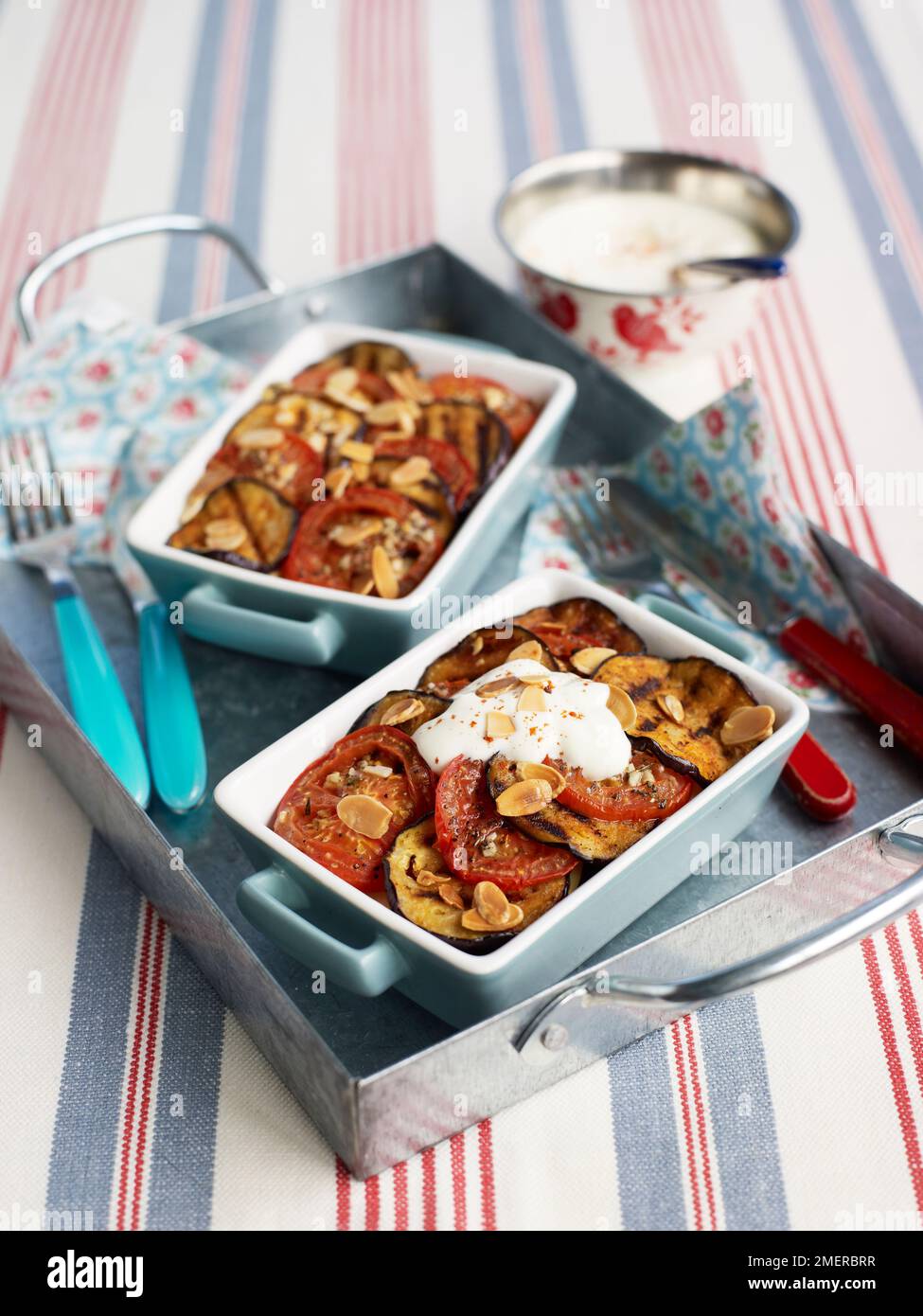 Melanzana e pomodoro in forno con mandorle tostate e panna Foto Stock