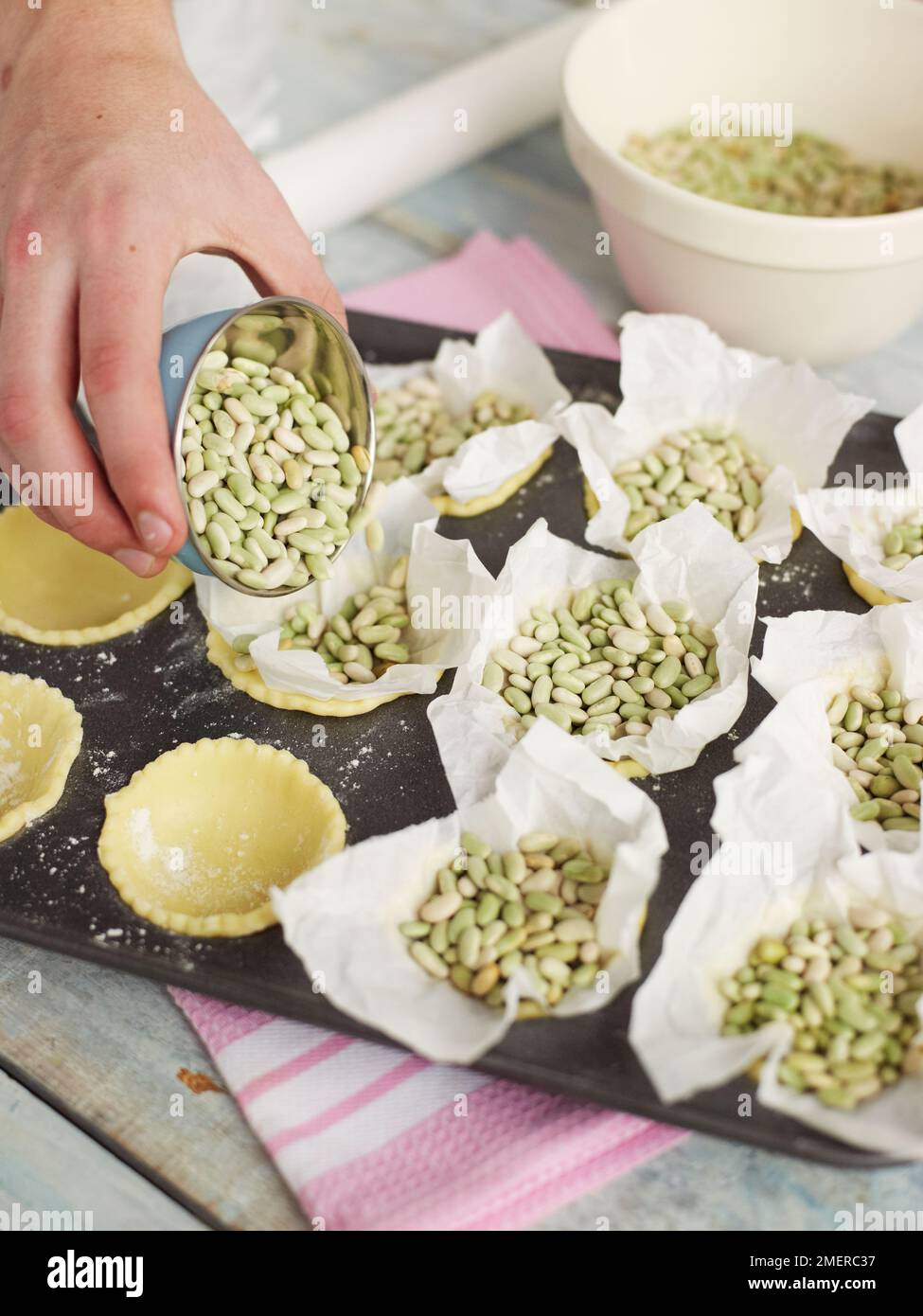Riempire le scatole di carta con fagioli per la cottura cieca, fare crostate di frutta Foto Stock