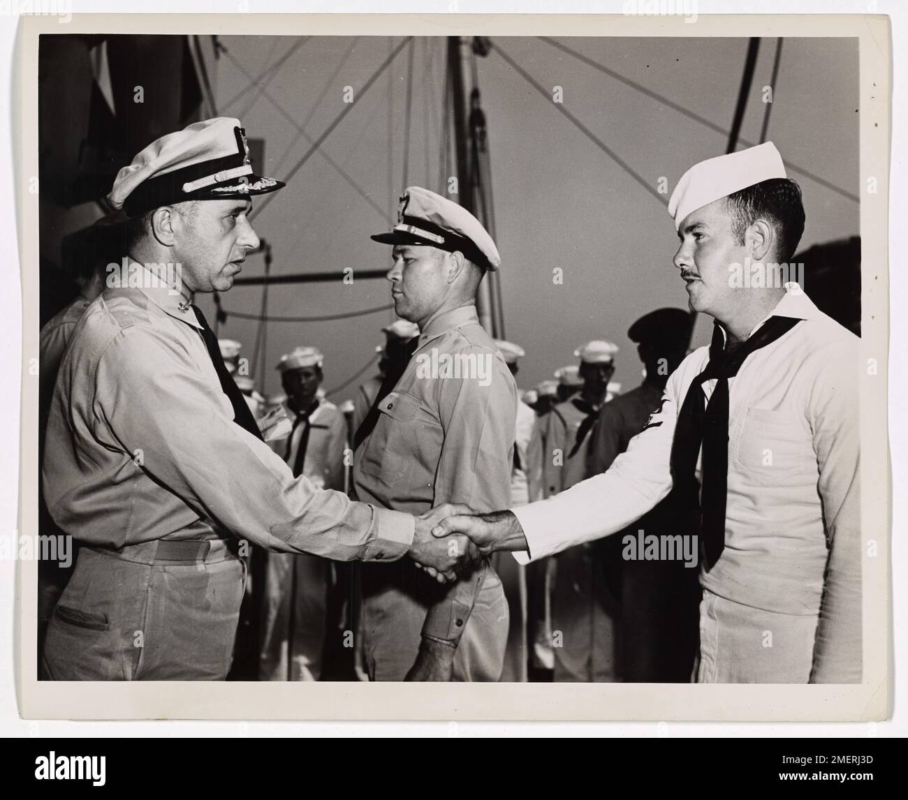 Il guardiano della costa Farrol D. Holloman, coxswain di McComb, signorina, riceve il Commendation Ribbon per aver salvato un uomo dall'annegamento nel canale di St. Georges. Il premio è stato consegnato dal capitano della Guardia Costiera Frank A. Leamy durante un raduno a bordo di un trasporto di invasione con equipaggio della Guardia Costiera nelle acque europee. Foto Stock