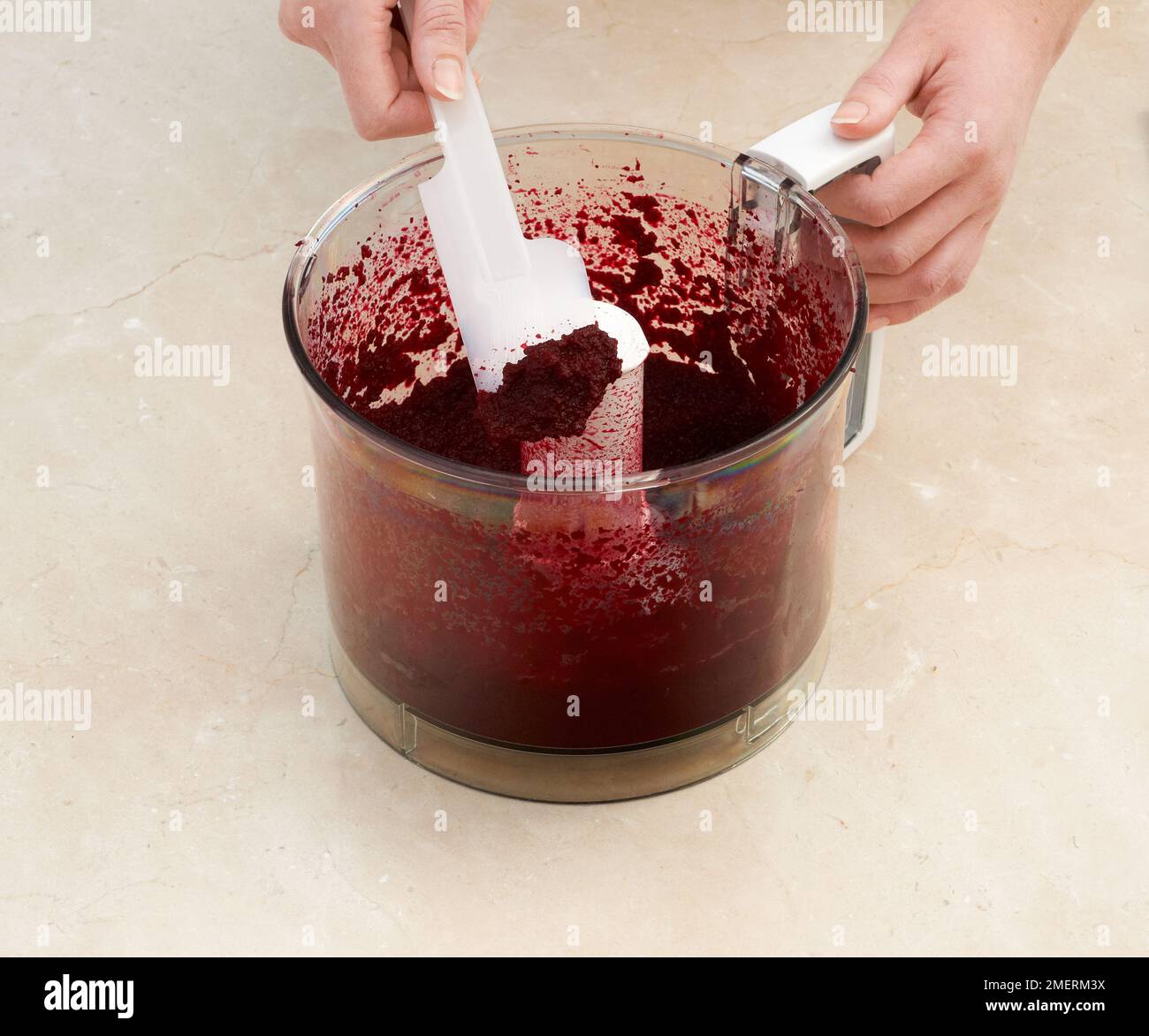 Mescolando il composto rosso della torta di velluto Foto Stock