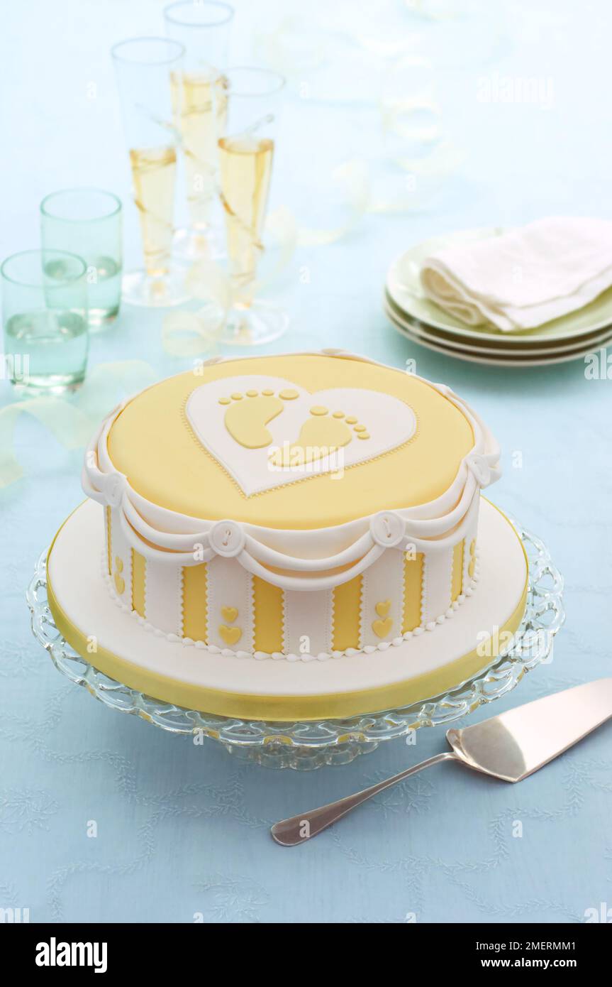 Torta di celebrazione neonato con glassa gialla fondente Foto Stock