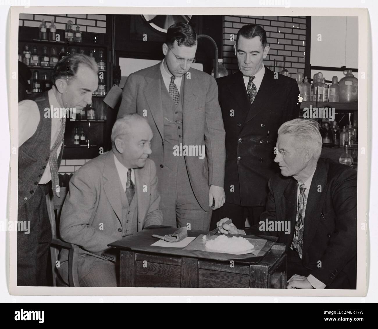 I membri della Guardia Costiera e della Mallinckrodt Chemical Company spiegano le proprietà del nitrato di ammonio in questa immagine educativa. Gli individui coinvolti nell'esperimento includono Mr. C. Fisher, J.E. Leek, Dr. John R. Ruhoff, Clay Clifton e H.V. Farr. Foto Stock
