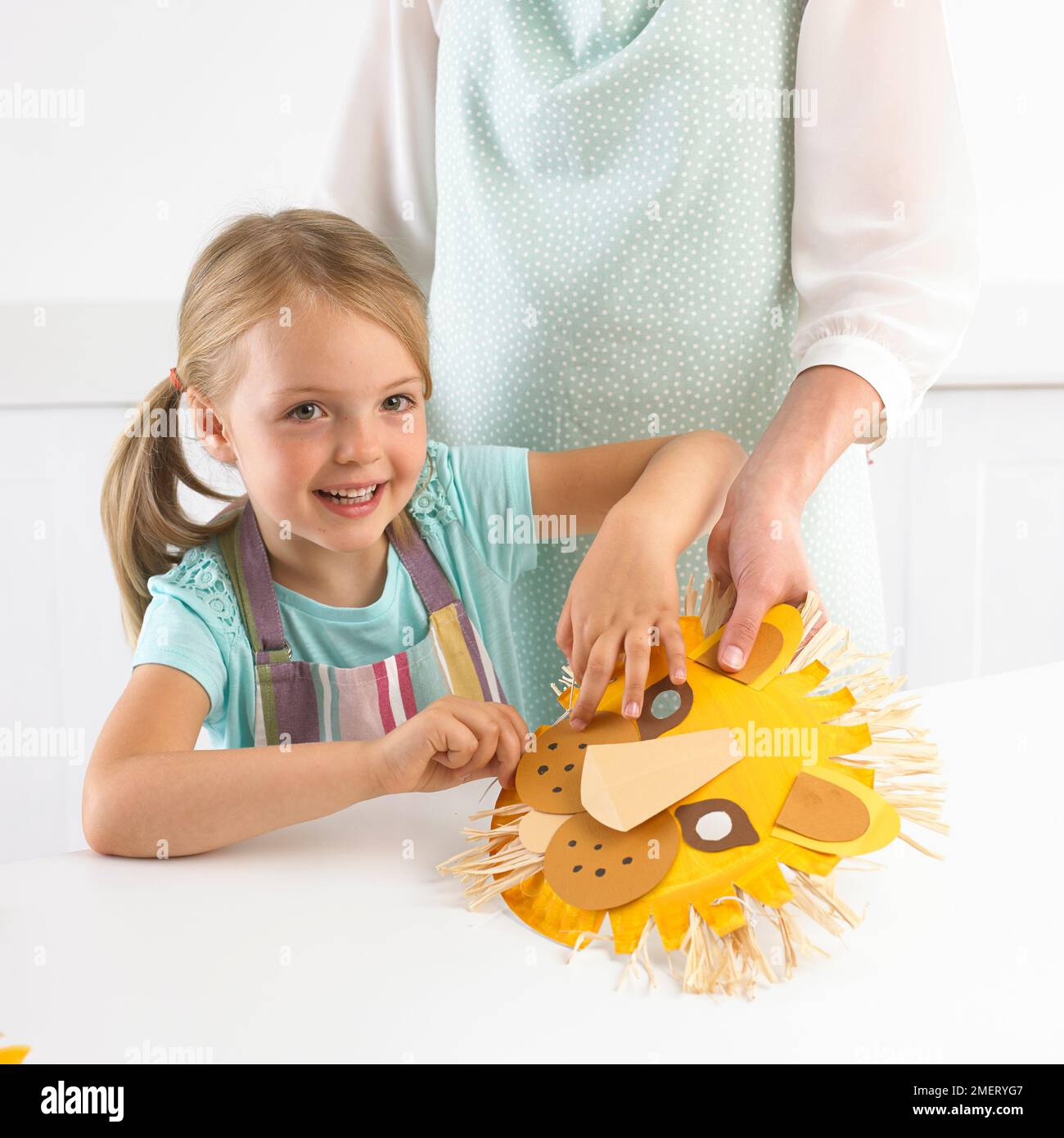 Ragazza che fa maschera di leone, 5 anni Foto Stock