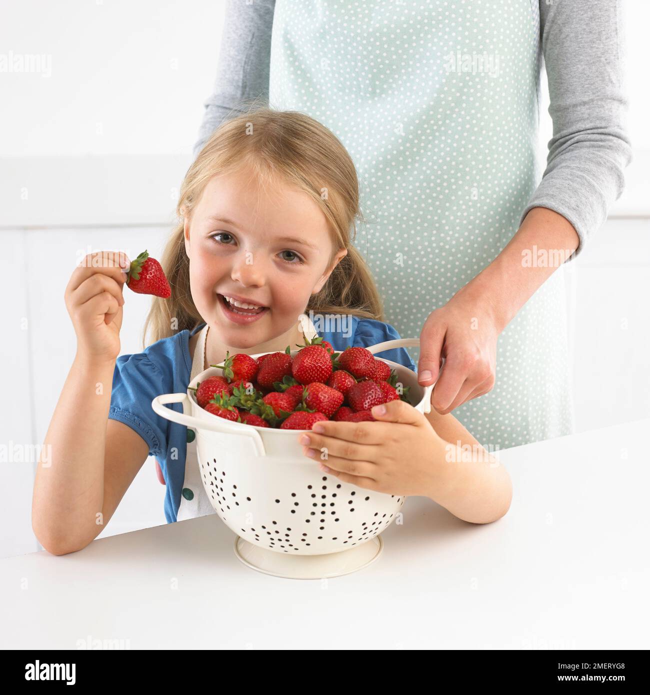 Ragazza e colino grande di fragole, 5 anni Foto Stock