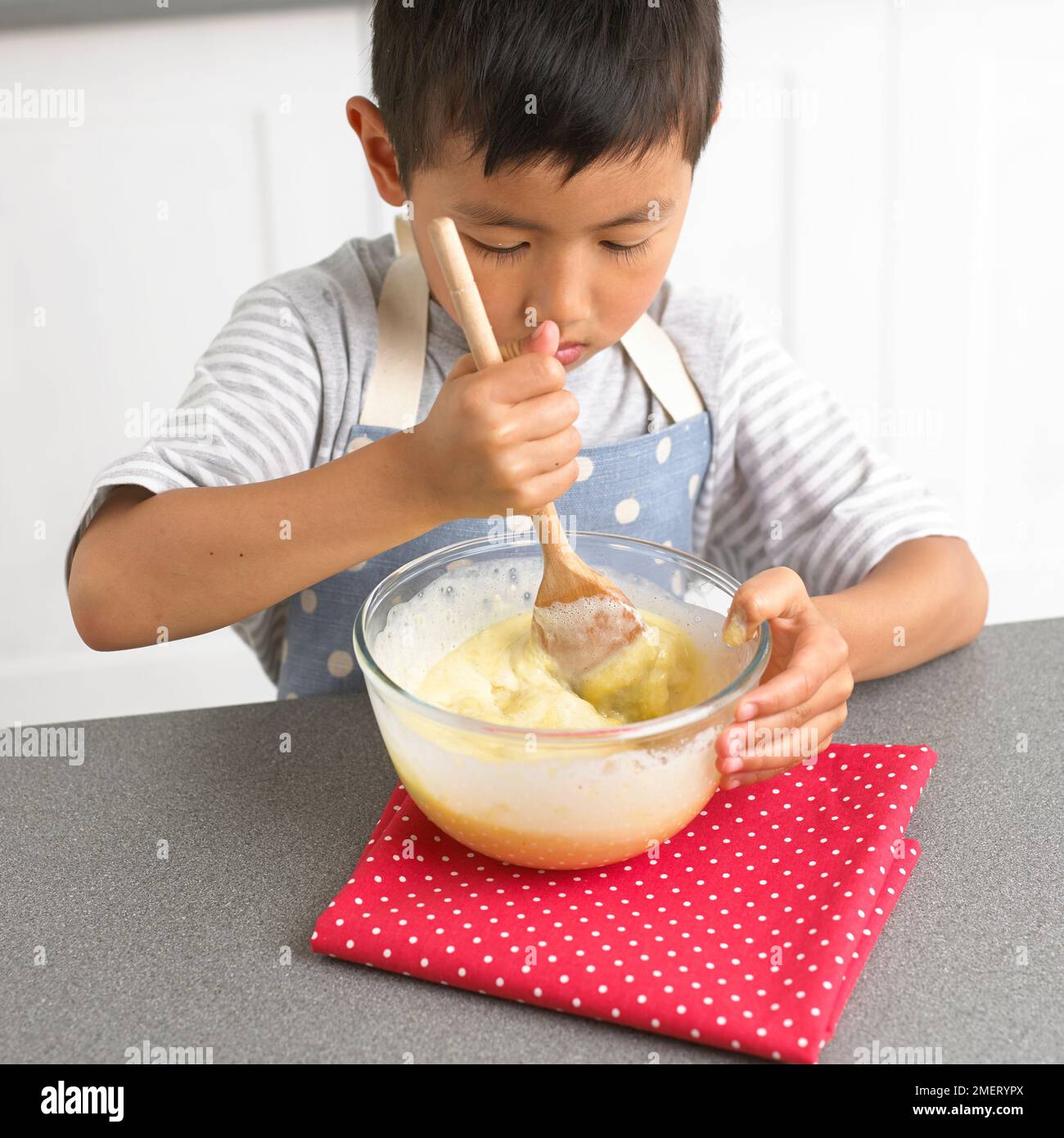 Rendendo il cioccolato bianco tartufi, ragazzo bianco di miscelazione miscela di cioccolato, 4 anni Foto Stock