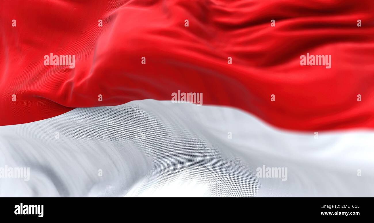 La bandiera nazionale indonesiana sventola nel vento. La Repubblica di Indonesia è uno Stato del Sud-est asiatico. Tessuto ondulato. Sfondo strutturato. Realistico Foto Stock