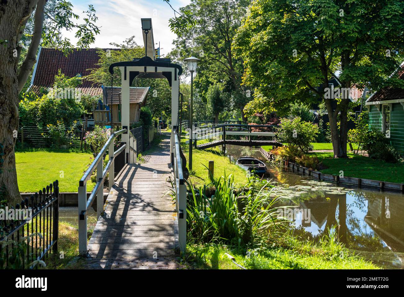 Scena del villaggio con ponte sul canale nel distretto di Kalverpolder, Zaandam, Olanda del Nord, Paesi Bassi Foto Stock