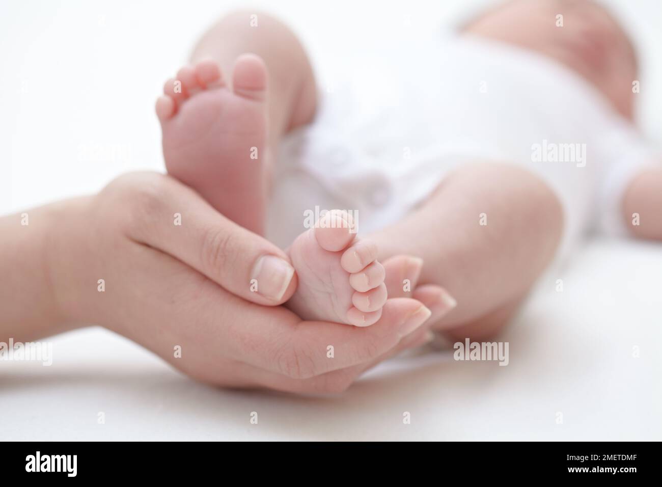 Madre che tiene i piedi della sua nuova bambina Foto Stock