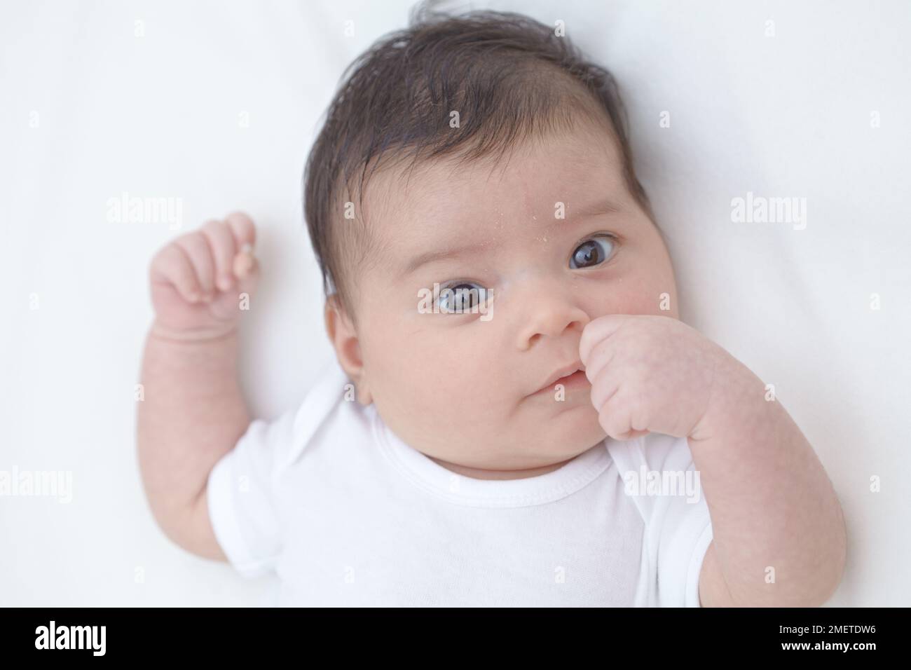Bambina (6 settimane) fare pugno, guardando la macchina fotografica Foto Stock