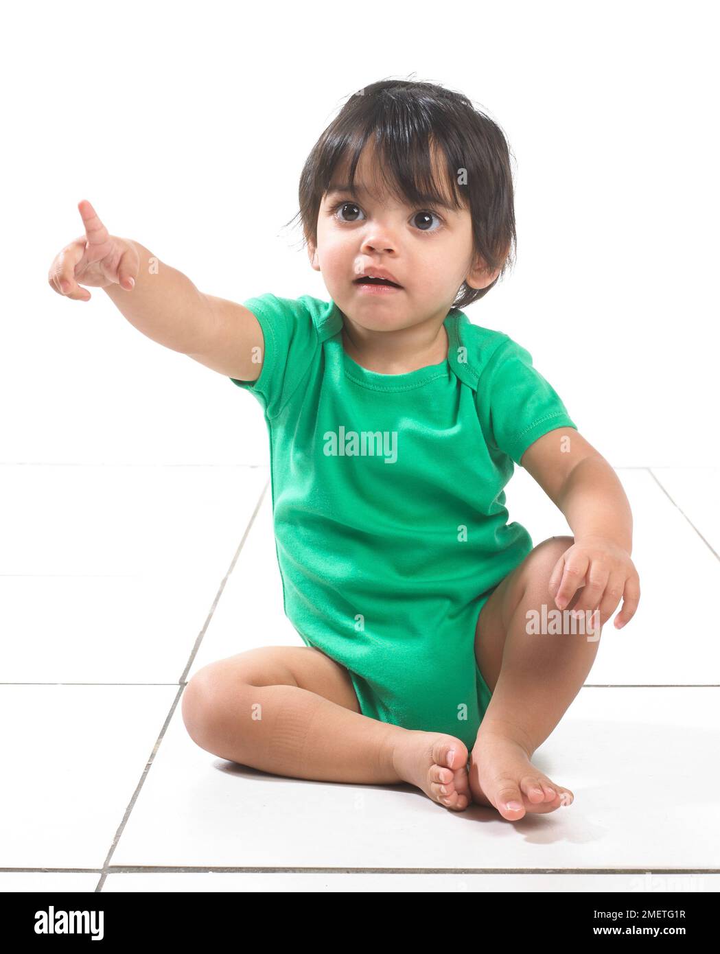 Bambino (16 mesi) seduto sul pavimento Foto stock - Alamy