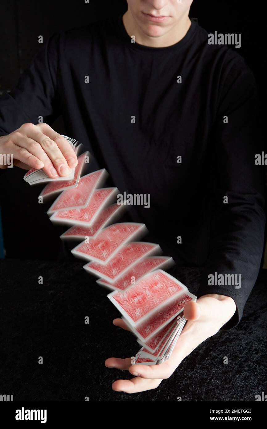 Un giovane che esegue il trucco della carta Foto Stock