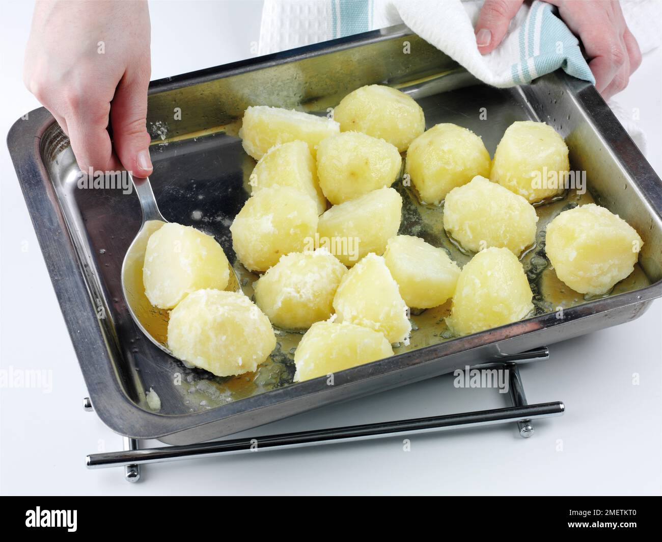 Preparare patate arrosto, mettere patate precotte in una teglia da forno e rivestirle con grasso d'oca Foto Stock