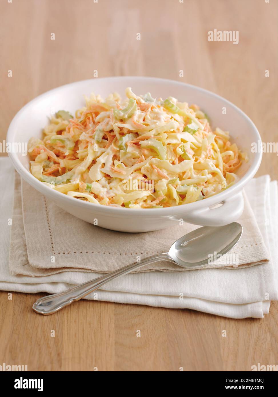 Ciotola di coleslaw su mucchio di tovaglioli, cucchiaio vicino a ciotola Foto Stock