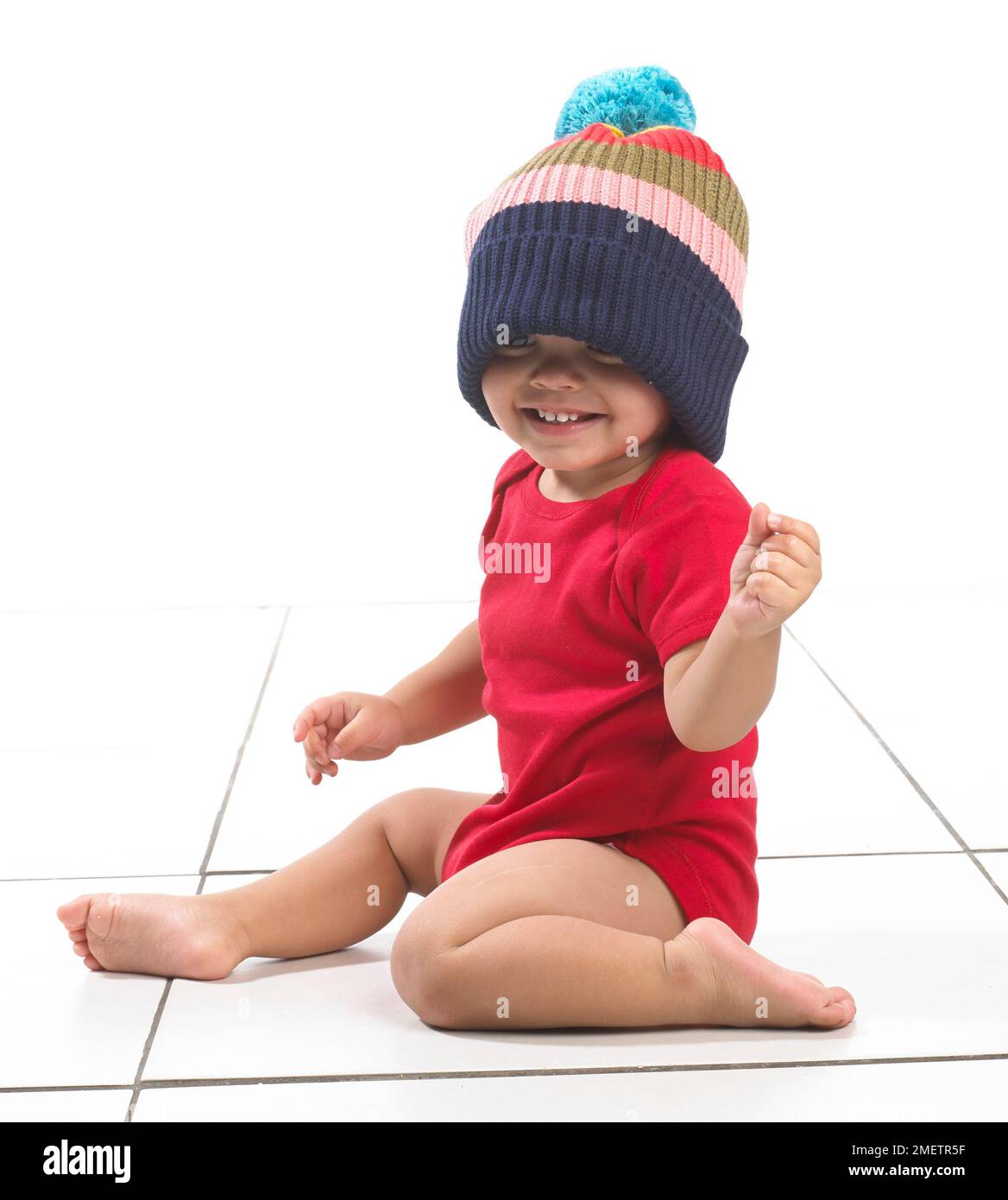Bambino (16 mesi) con cappello colorato a righe Foto Stock