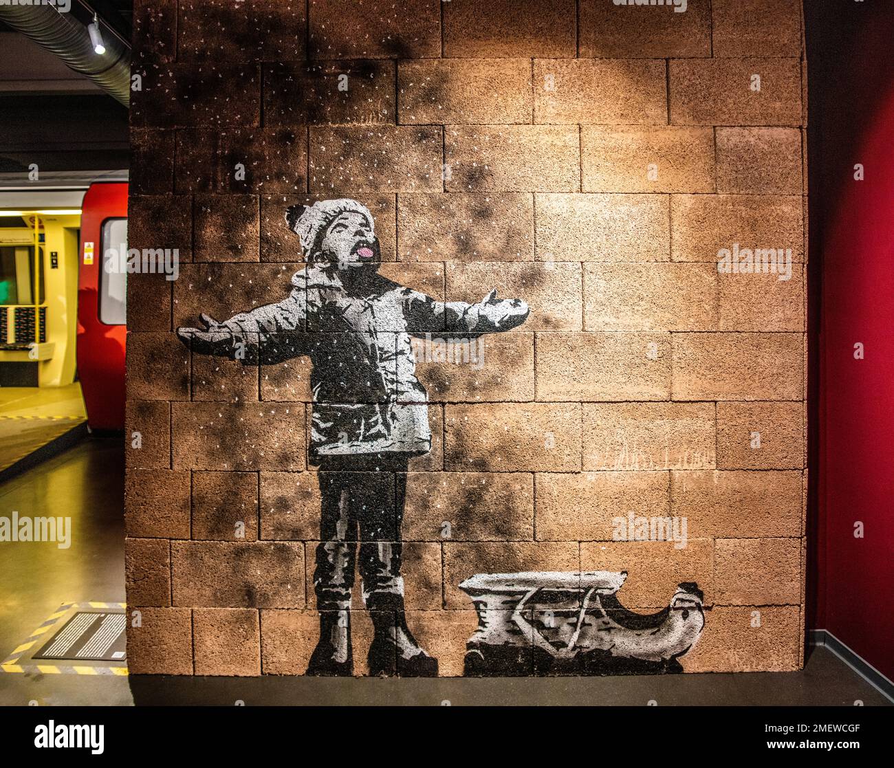 Seasons Greetings, angolo parte 1, bambino che gioca con presunta neve che è cenere da spazzatura bruciante bin, 2018, Banksy, mostra sulla strada Foto Stock