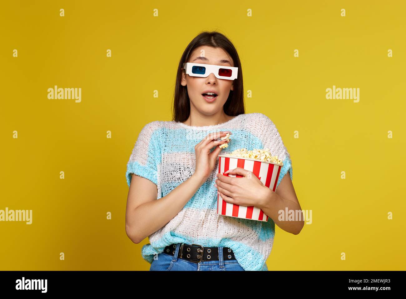donna in 3d bicchieri che tiene un secchio di popcorn Foto Stock