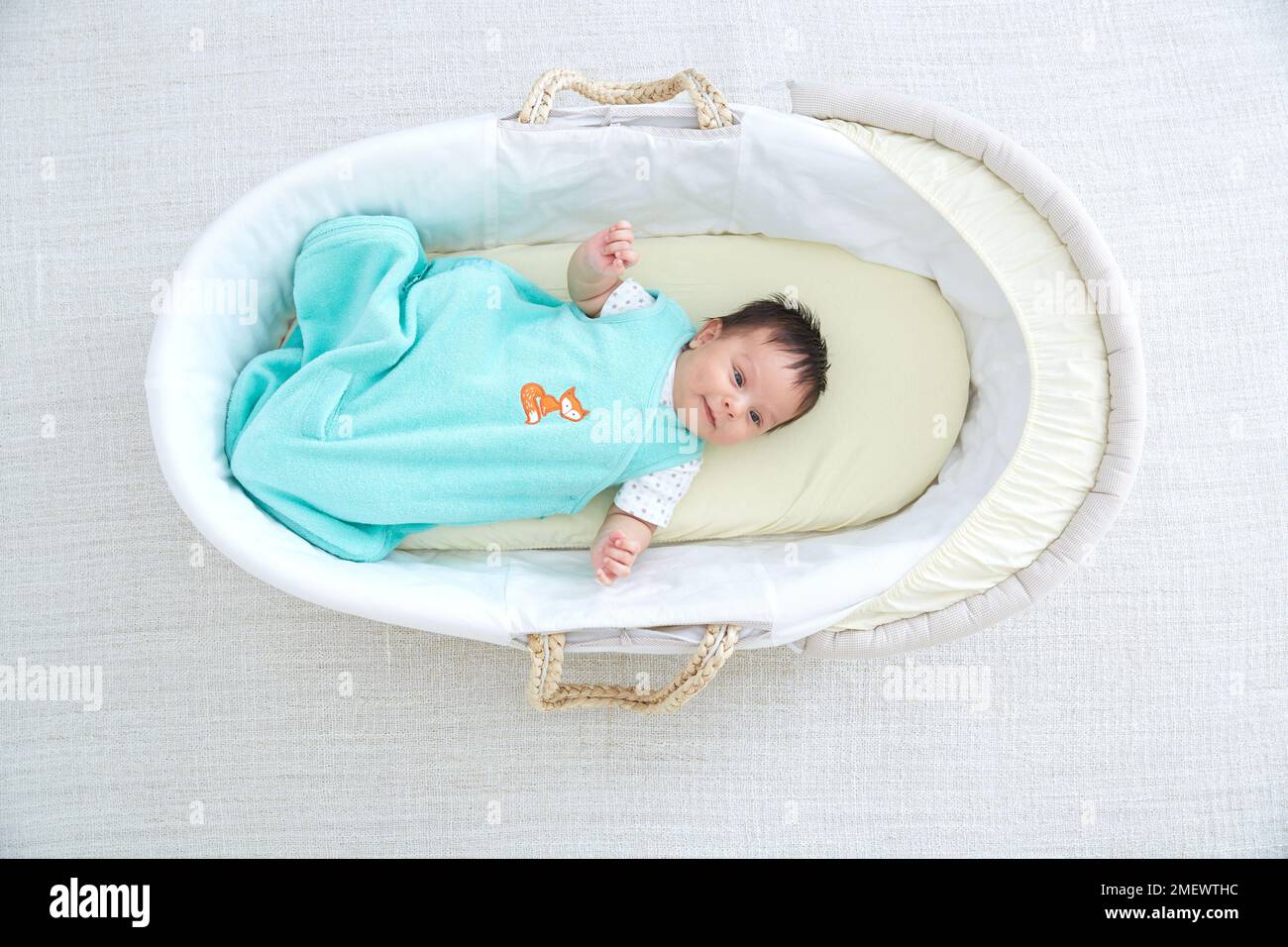 Bambino in un sacco a pelo in un cestino di mosè Foto Stock