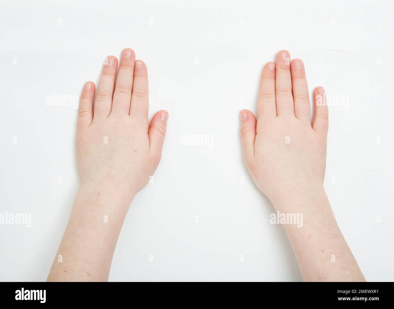 Le mani dei bambini dimostrano il movimento delle placche tettoniche. Confine divergente Foto Stock