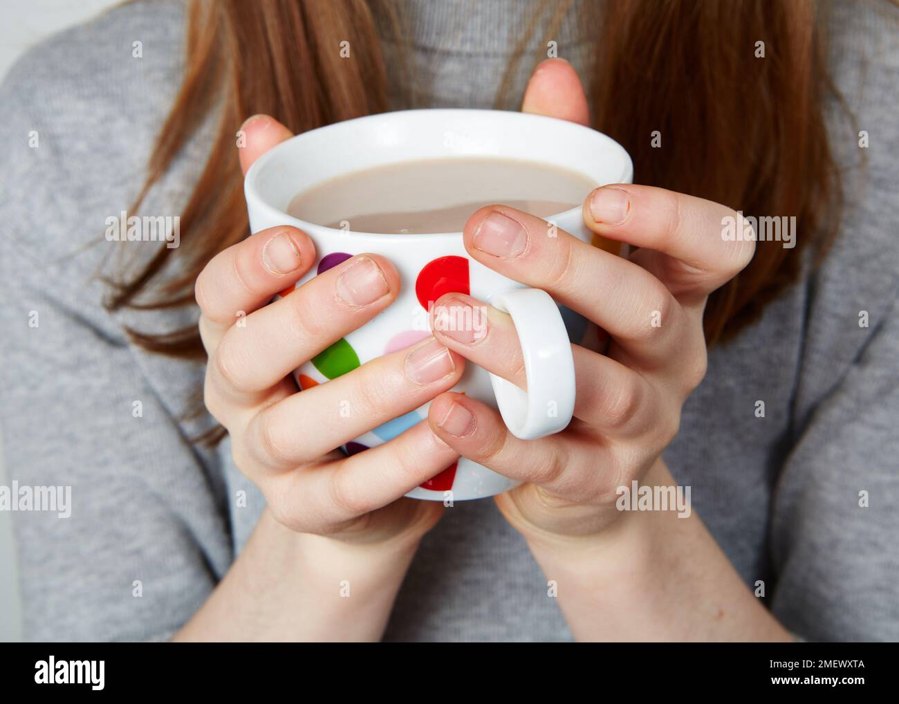 Bambino di bere una bevanda calda da un macchie mug Foto Stock