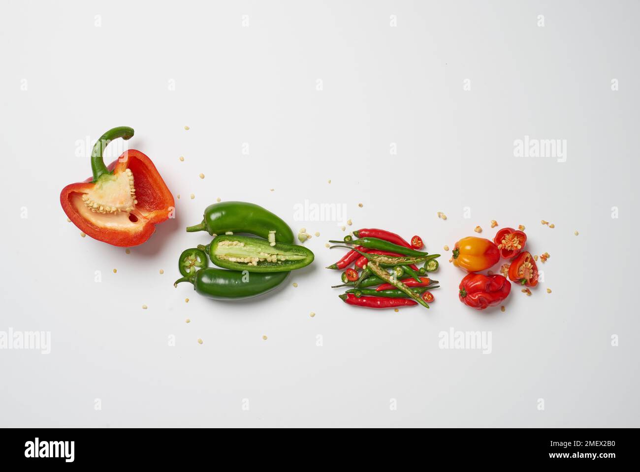 I bambini, con semi sparsi, tagliati aperti e disposti da miti a caldi; peperone, jalapeÒos, peperoncini, cobani scotch Foto Stock