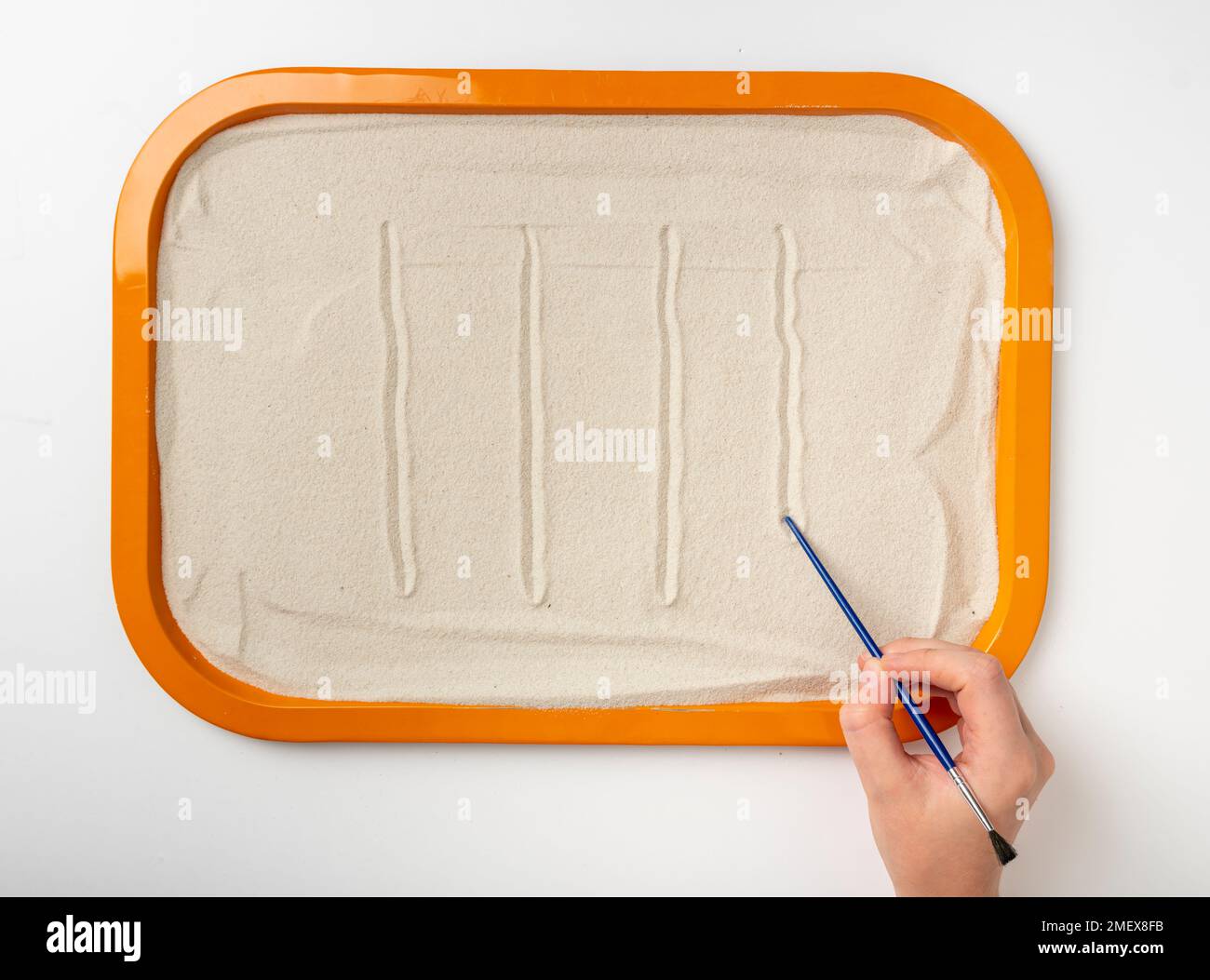 Disegnare a mano linee di vertilcolo in sabbia Foto Stock