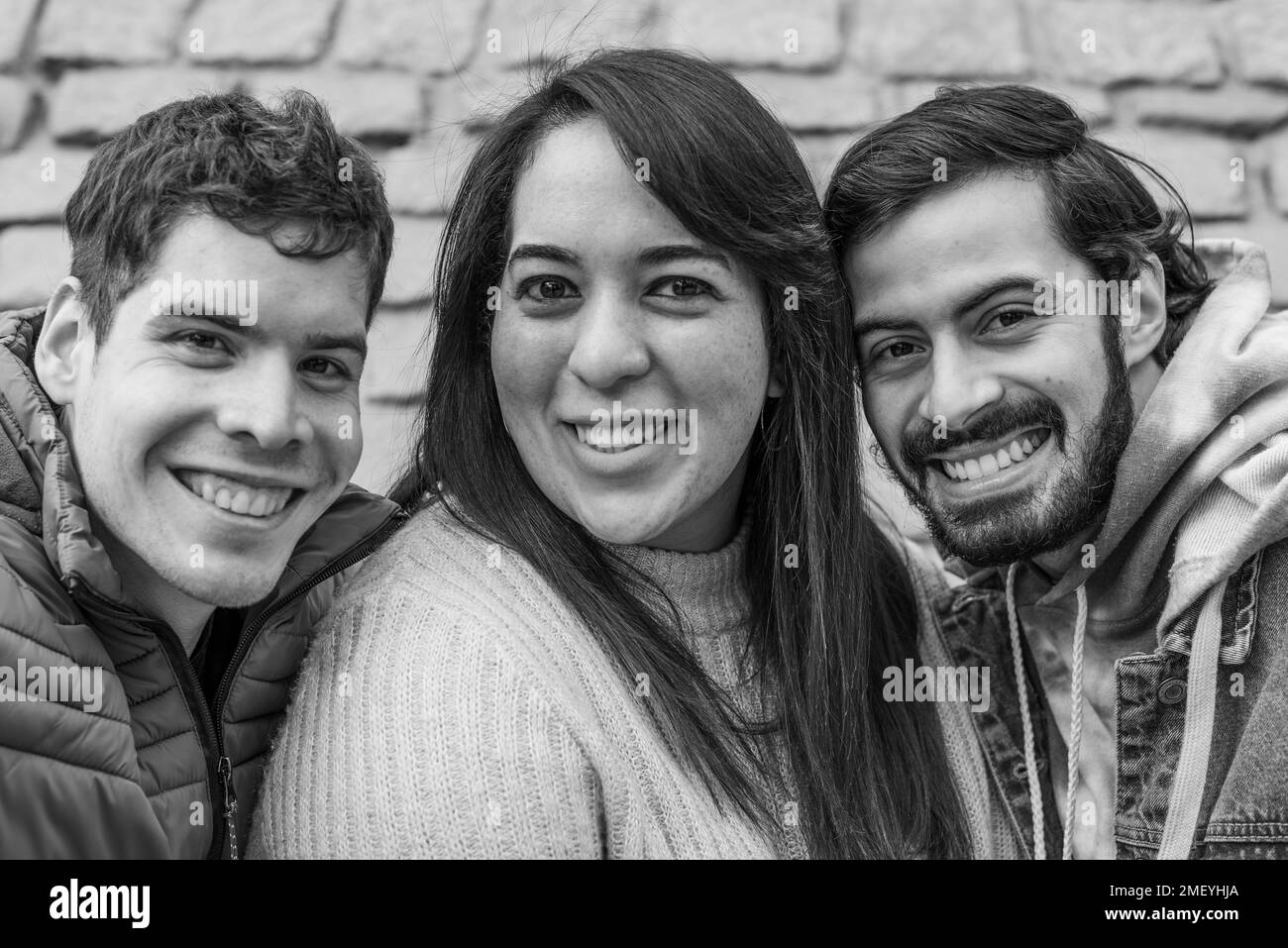 Ritratto di tre amici felici in bianco e nero. Stanno guardando la fotocamera Foto Stock