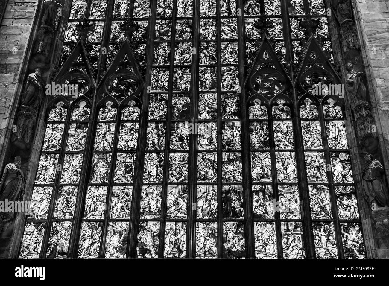 Milano, Lombardia, Italia - Aprile 2019: Scene religiose su vetrata all'interno del Duomo di Milano; la cattedrale di Milano in bianco e nero Foto Stock
