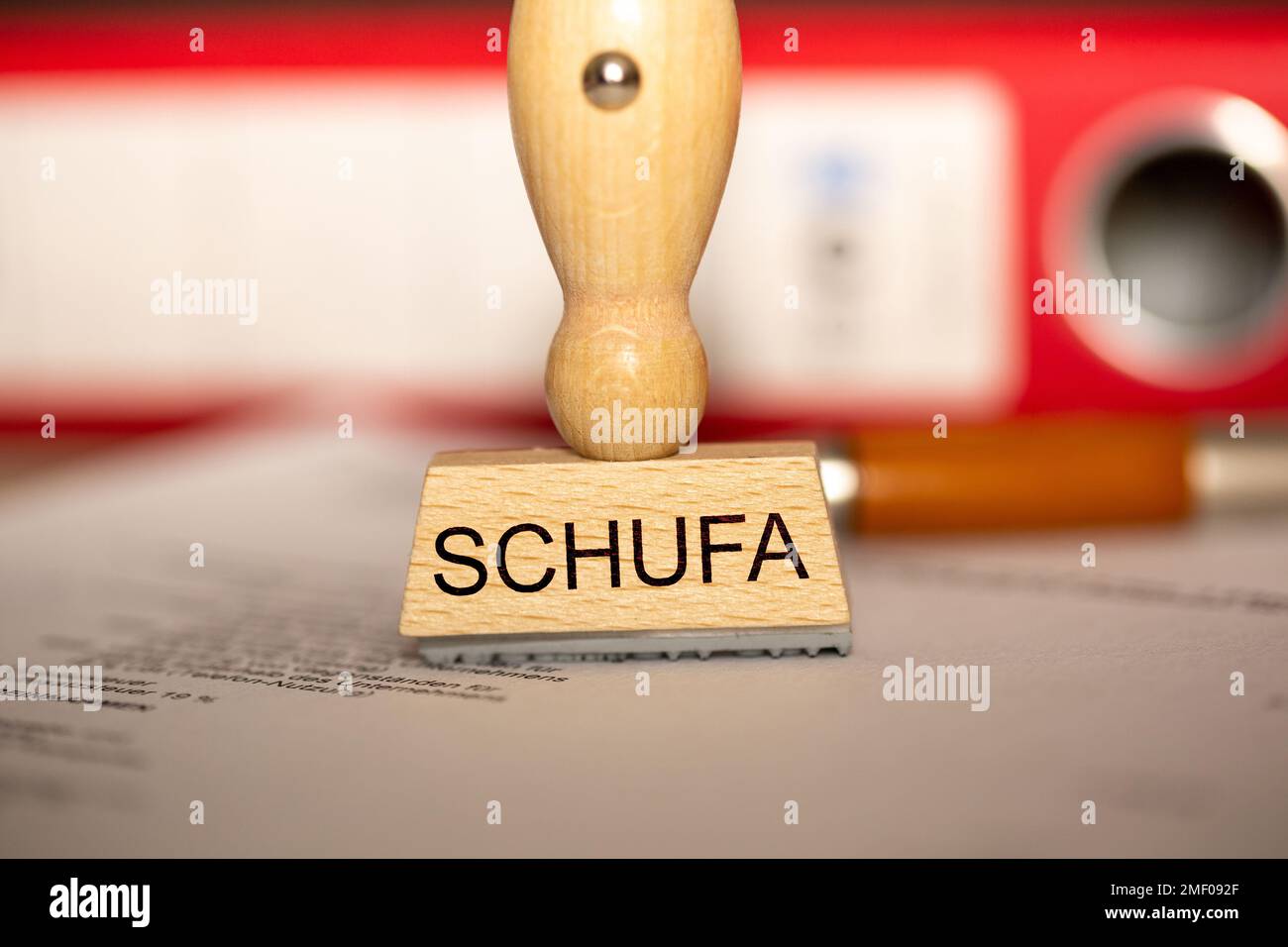 Immagine simbolo Schufa: Francobollo su una scrivania con documenti e cartelle (Schufa Holding AG, è un'agenzia di credito tedesca la sua attività è di fornire il suo contratto Foto Stock