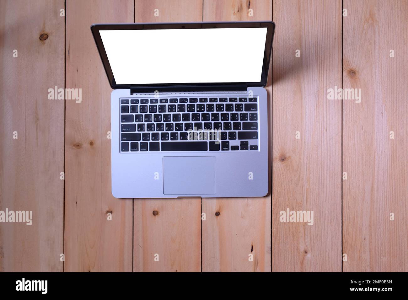 Computer portatile portatile aperto su display bianco posto su un tavolo di legno per il lavoro, l'intrattenimento, i social media e lo shopping online Foto Stock