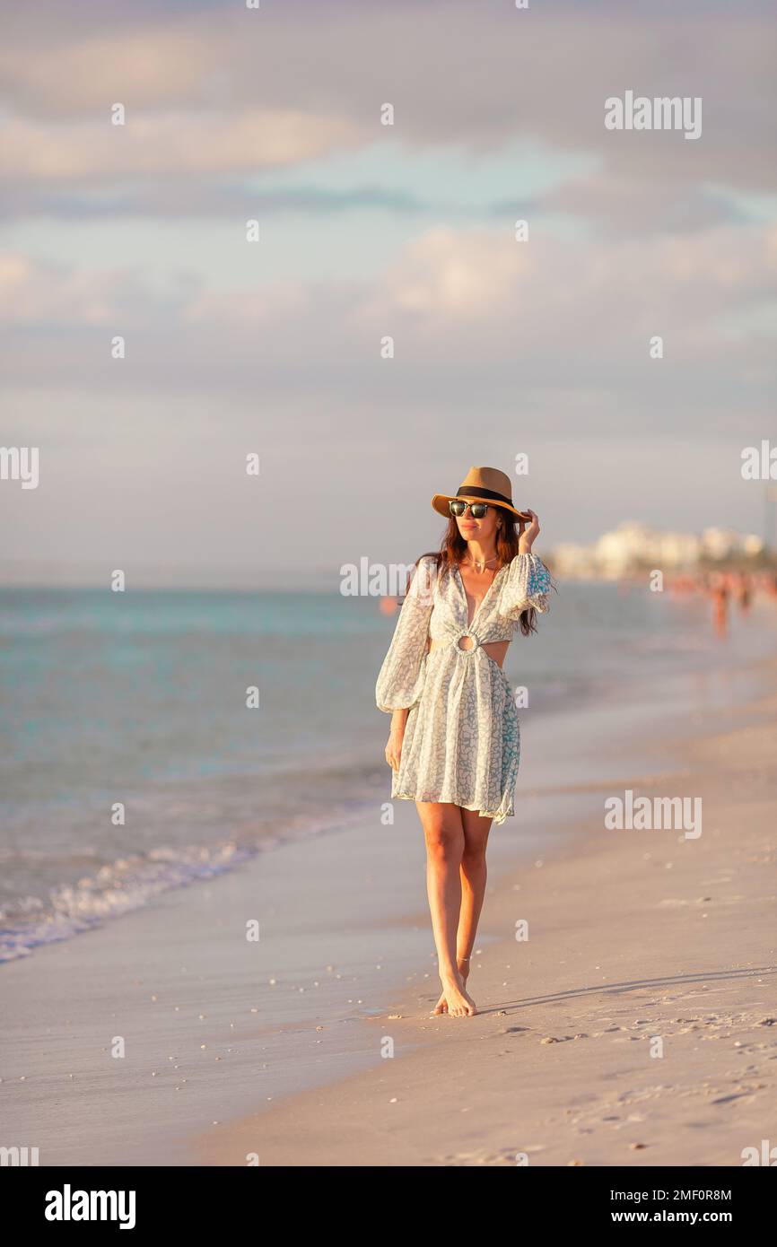 Giovane donna felice sulla spiaggia godere la sua vacanza estiva al tramonto Foto Stock