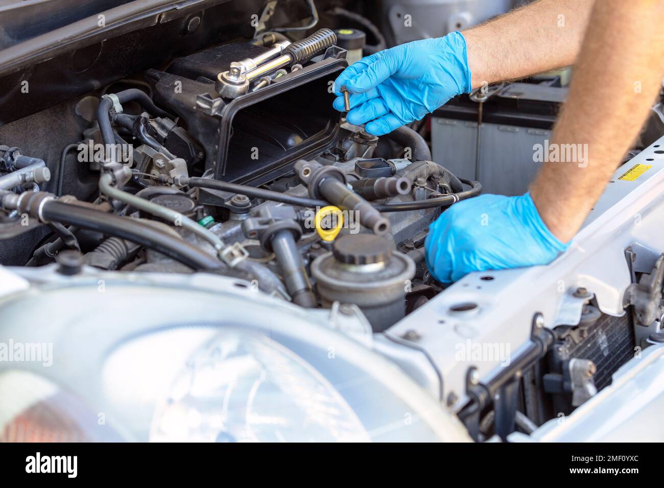 Sostituzione o sostituzione della candela e della bobina di accensione della vettura. Riparazione del motore del veicolo. Foto Stock