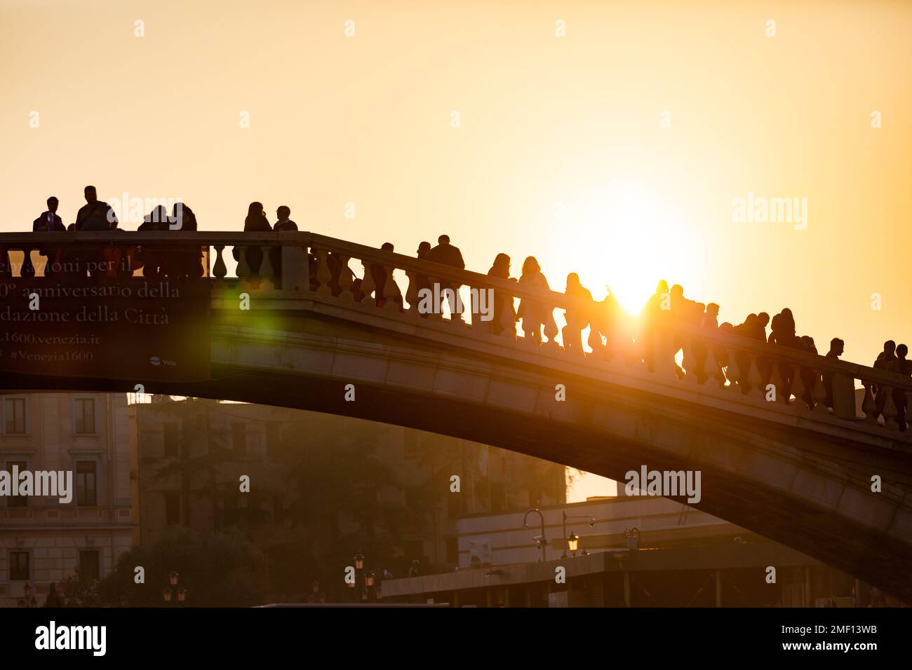 Sagoma di persone in piedi sul Ponte degli Scalzi sul Canal grande in prima serata con il sole sullo sfondo, Venezia, Italia. Foto Stock