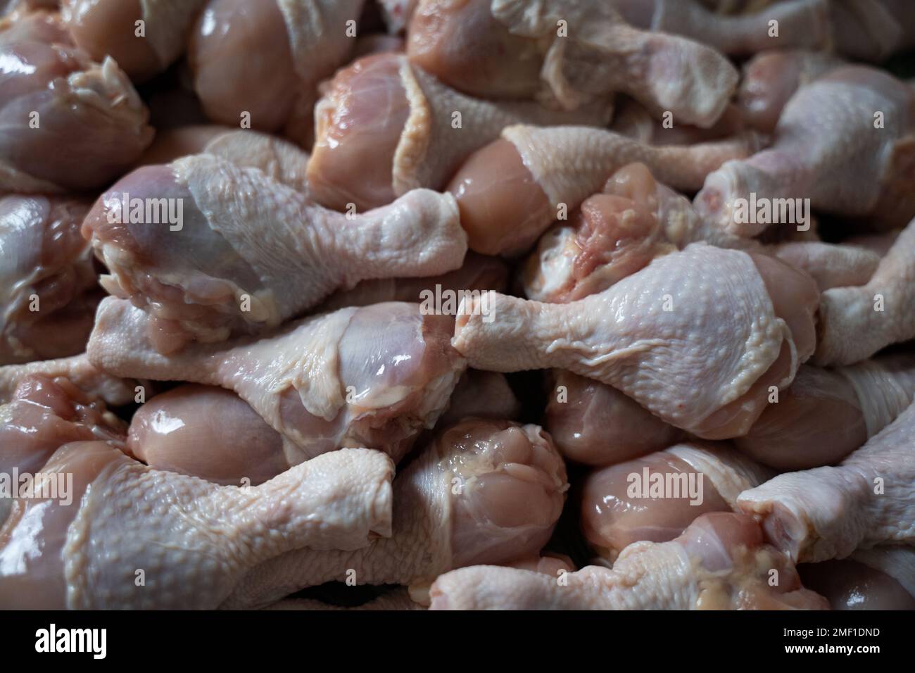 Cosce di pollo crude grandi mucchio sullo sfondo del tavolo Foto Stock