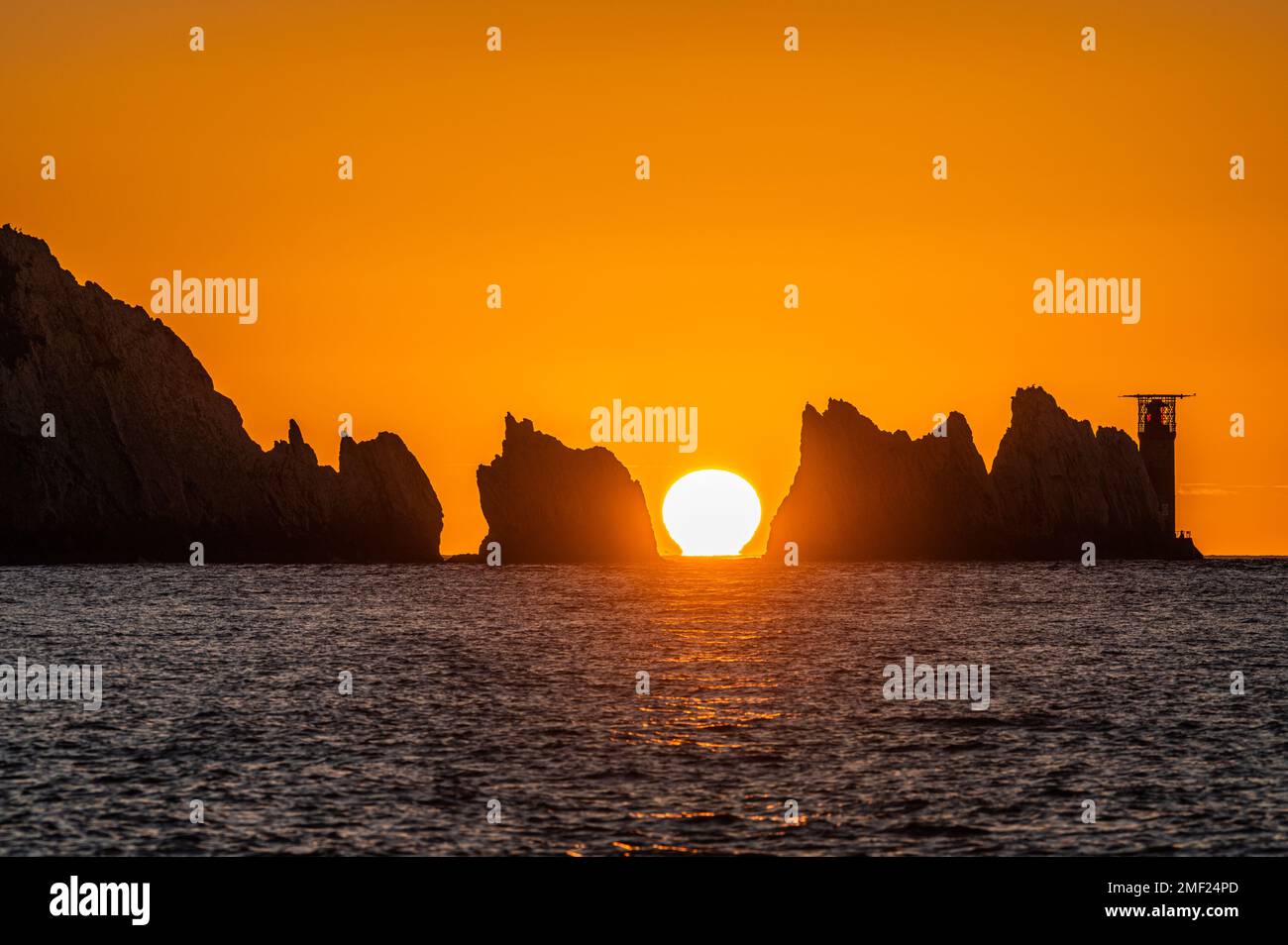 Tramonto a The Needles Rocks, Isola di Wight. il sole bacia la superficie dell'acqua Foto Stock
