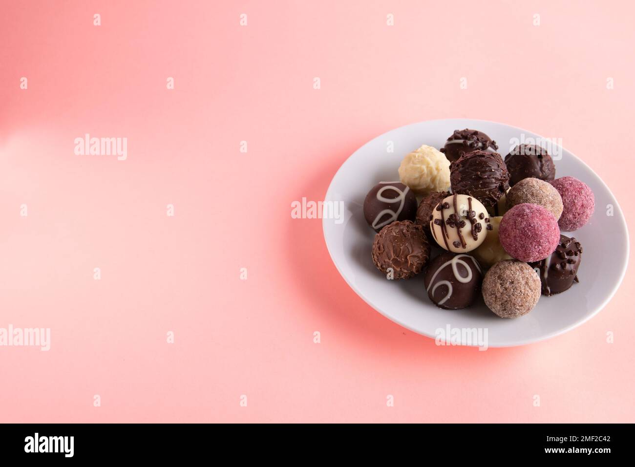 foto diverse caramelle giacenti su un piatto su uno sfondo colorato Foto Stock