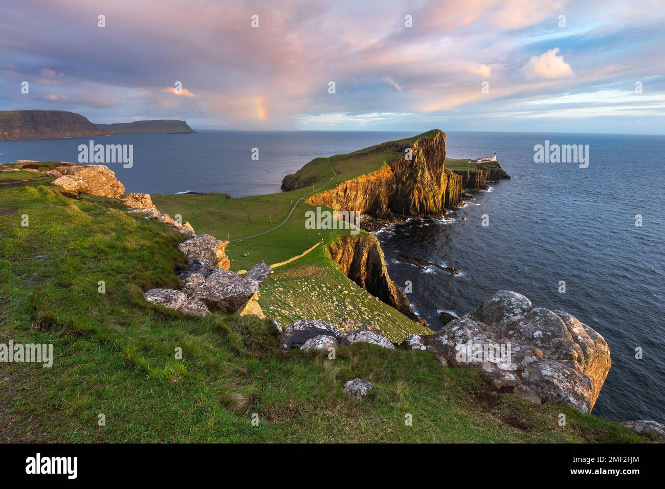 Incredibile vista del faro di Neist Point con arcobaleno sulla costa. Isola di Skye, Scozia, Regno Unito. Foto Stock