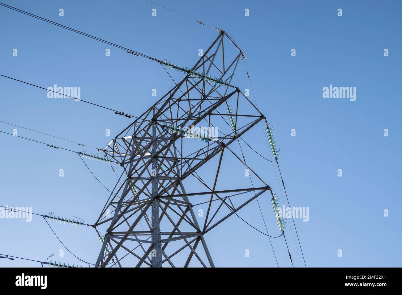 Electircity pylons contro un cielo blu chiaro in una fredda giornata di inverni nello staffordshire Foto Stock