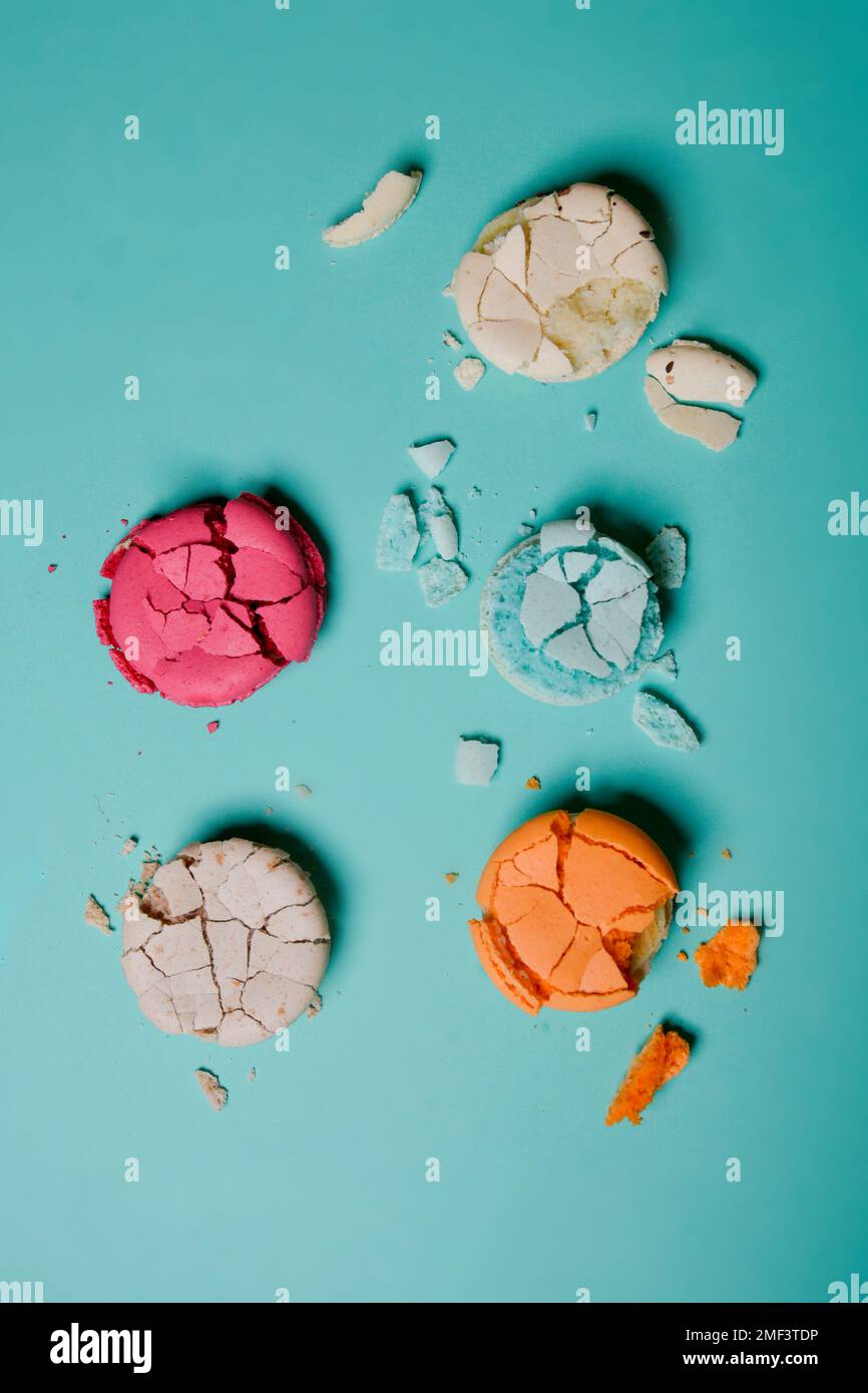 Macaron schiacciato, spezzato, dessert di colore francese su sfondo blu Foto Stock