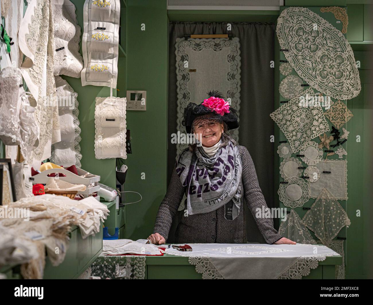 Donna anziana elegante si alza al bancone in un negozio di merletti Foto Stock