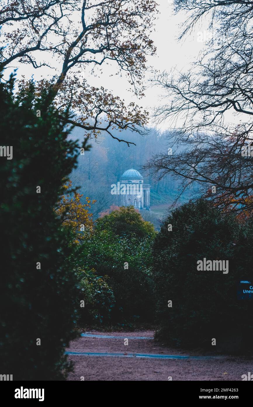 Uno scatto verticale del bellissimo parco con molti alberi verdi e piante sullo sfondo dell'edificio Stourhead a Stourton, Warminster, Regno Unito Foto Stock
