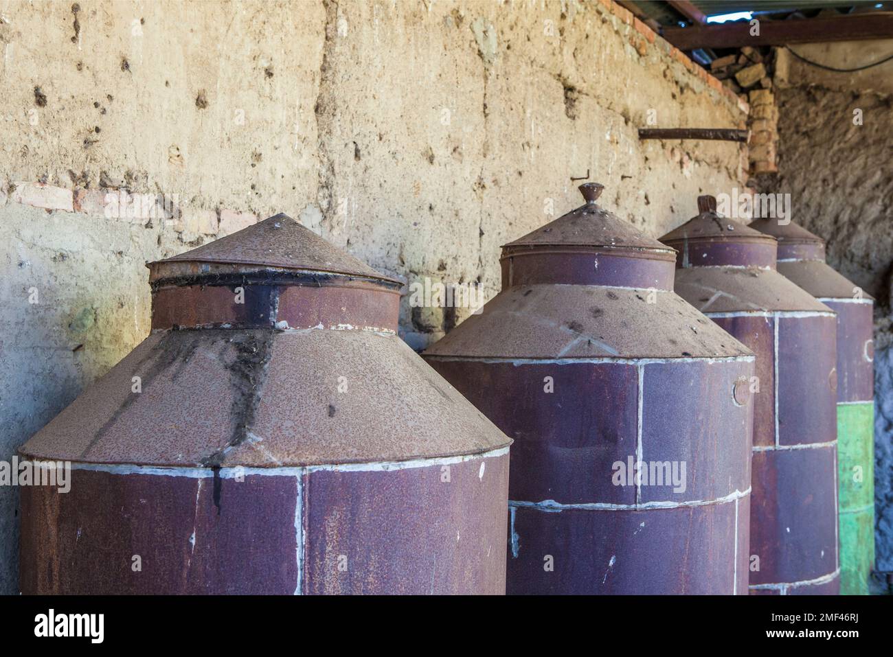 Fusti di olio d'oliva arrugginiti in disuso. Vecchio sfondo fattoria Foto Stock