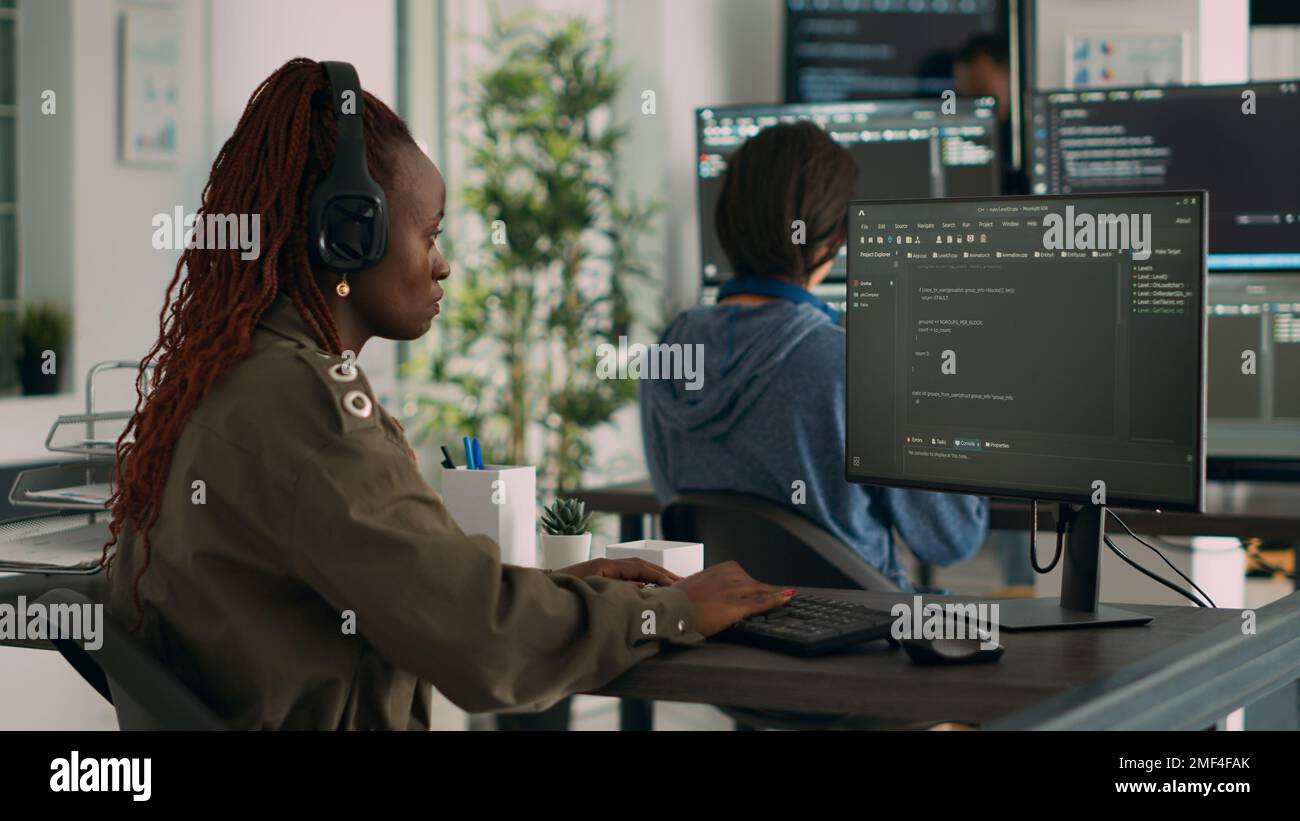 Ingegnere software afroamericano che lavora si è concentrato sulla programmazione del linguaggio IT al computer, digitando script html. Programmatore di database che scrive codice con algoritmi nella finestra terminale. Foto Stock