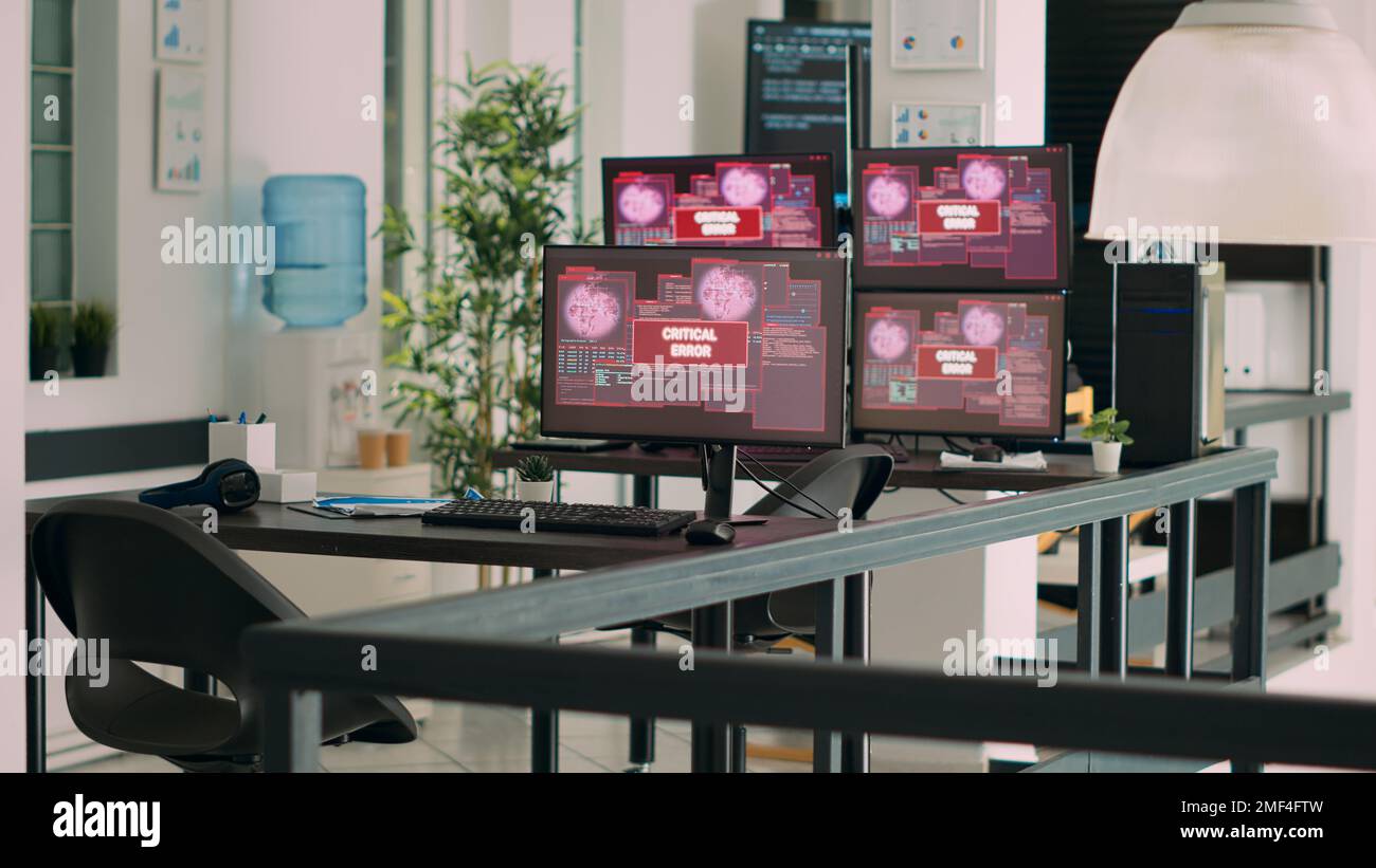 Ufficio dell'agenzia vuoto con più monitor che mostrano l'avviso di arresto anomalo del sistema sul display, messaggio di errore critico lampeggiante sullo schermo. Computer che mostrano un malfunzionamento della violazione della sicurezza alla scrivania. Foto Stock