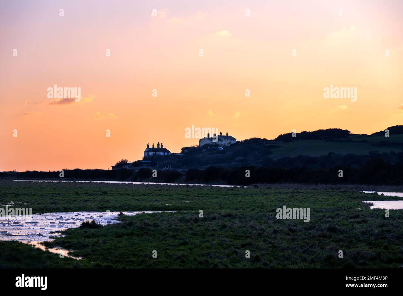 SEAFORD, INGHILTERRA - 21st GENNAIO 2023: Vista dei cottage della guardia costiera al tramonto in inverno, Cuckmere Haven, Sussex orientale Foto Stock