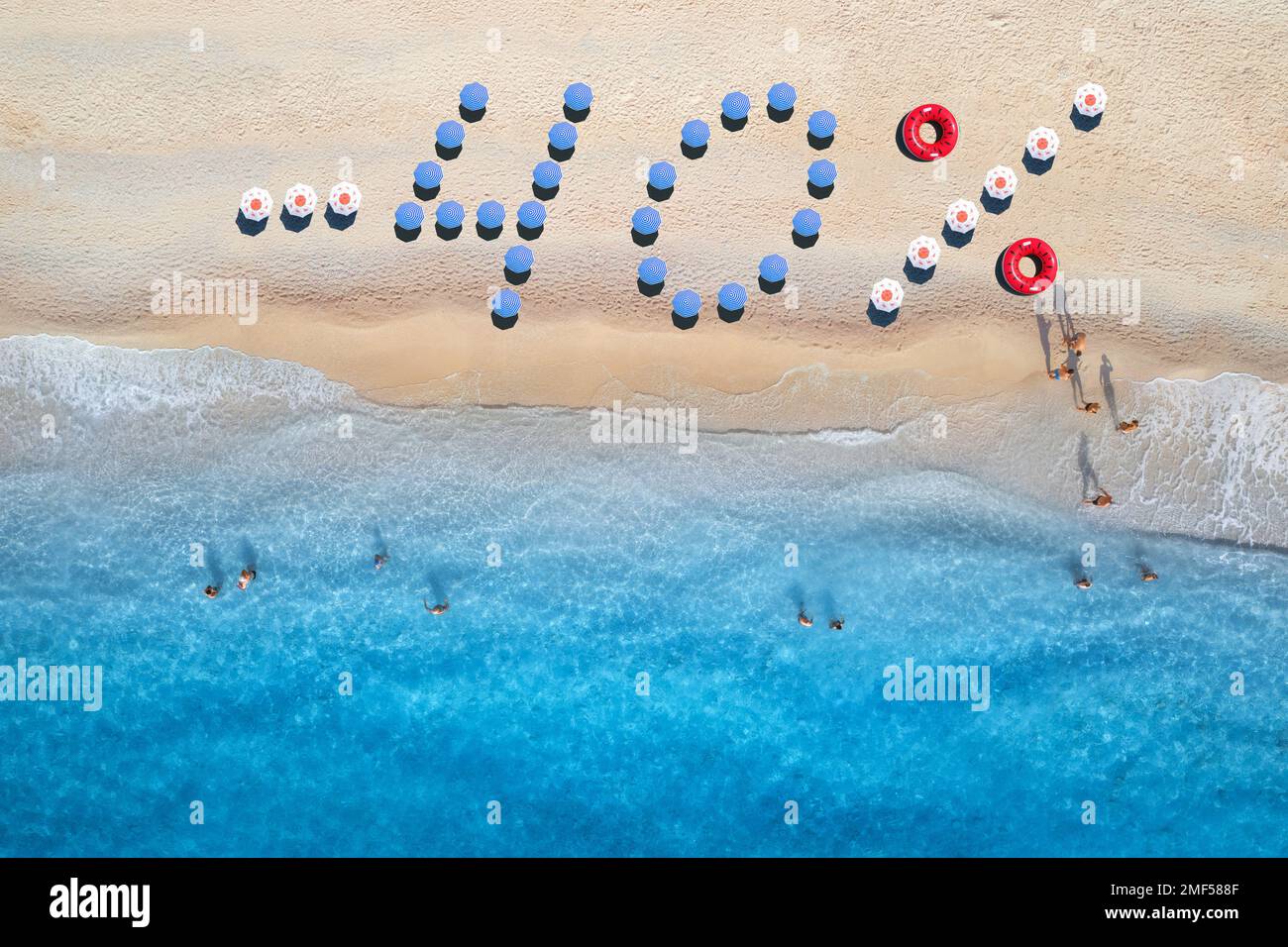 Testo creativo - 40 realizzato con ombrelloni colorati su spiaggia sabbiosa Foto Stock